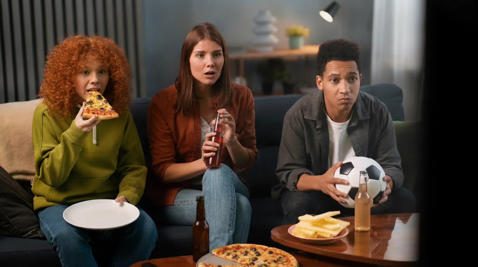 poeple watching fifa cup and eating pizza