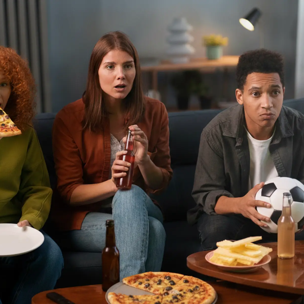 poeple watching fifa cup and eating pizza